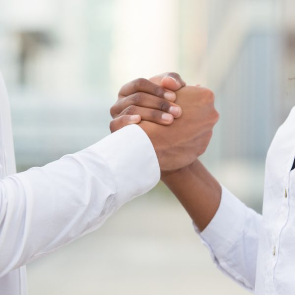 Deux personnes qui se serrent la main pour s'encourager.