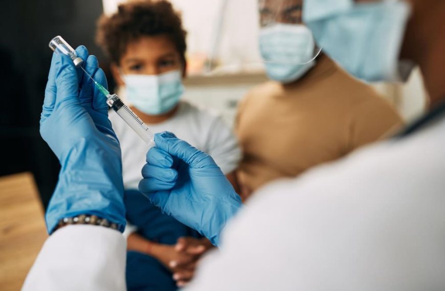 Un docteur qui va vacciner un enfant.